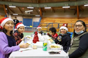 a photo of young Siksika disabilities clients and their teachers aide at the Christmas dinner.